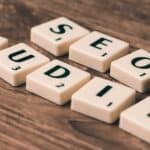 Scrabble tiles spelling SEO Audit on wooden surface, symbolizing digital marketing strategies.