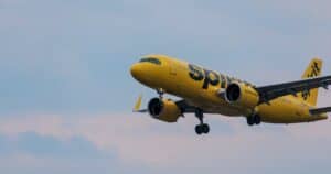 A Spirit Airlines yellow jet in flight over Atlanta, showcasing aviation and travel.