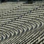 Wide angle view of empty stadium bleachers with a geometric pattern, showcasing rows of seats in a sports venue.