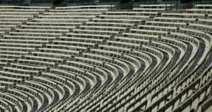 Wide angle view of empty stadium bleachers with a geometric pattern, showcasing rows of seats in a sports venue.