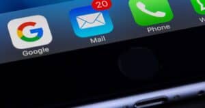 A close-up photo of a smartphone displaying popular apps like Google and Mail.